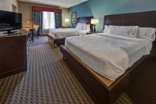 塔尔萨塔尔萨市中心希尔顿花园酒店的一间酒店客房,配有一张大床和一台平面电视