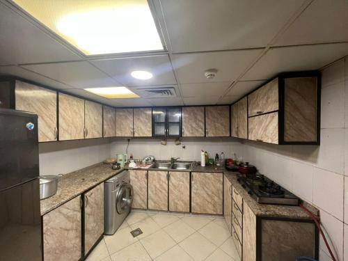 阿布扎比Furnished Regular Room in shared Apartment的厨房配有木制橱柜、水槽和洗碗机。