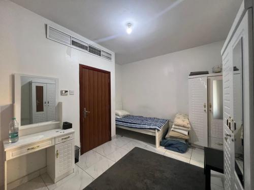 阿布扎比Furnished Regular Room in shared Apartment的浴室设有床、水槽和镜子
