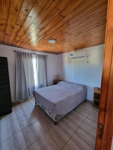 维拉卡洛斯帕兹Terrazas de Estancia的一间卧室设有一张床和木制天花板