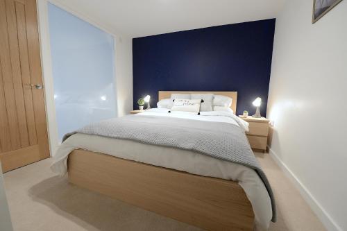 沃金Ground Floor One Bedroom Flat Centre of Woking with Off Street Parking的一间卧室设有一张蓝色墙壁的大床