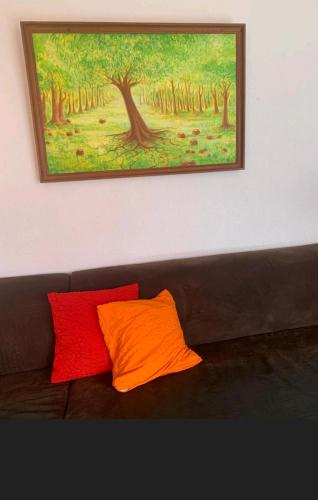 VilleretChez Ninfa的画作下沙发上的橙色和红色枕头