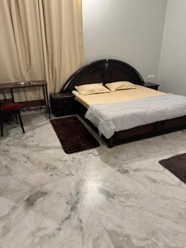 瓦拉纳西Riya Villa (Kaashi Flora Unit)的一间铺有大理石地板的卧室,配有一张床。