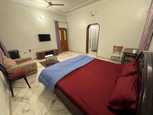 瓦拉纳西Riya Villa (Kaashi Flora Unit)的一间卧室配有一张床、一张沙发和一台电视