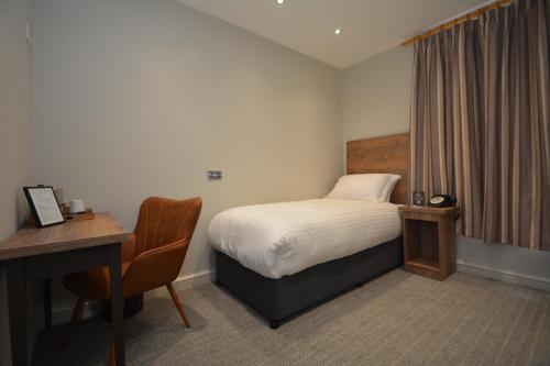 拉格比橄榄球酒店 的酒店客房配有一张床、一张书桌和一张书桌。