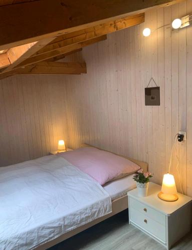 VilleretChez Ninfa的一张位于带两盏灯和一张桌子的房间的床铺