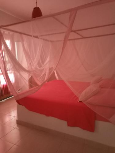 索蒙Villa Savana的卧室配有带蚊帐的红色床