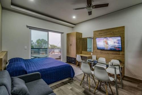 瓦兹特佩克Sierra Apartments Estudios en Oaxtepec的卧室配有一张床和一张桌子及椅子