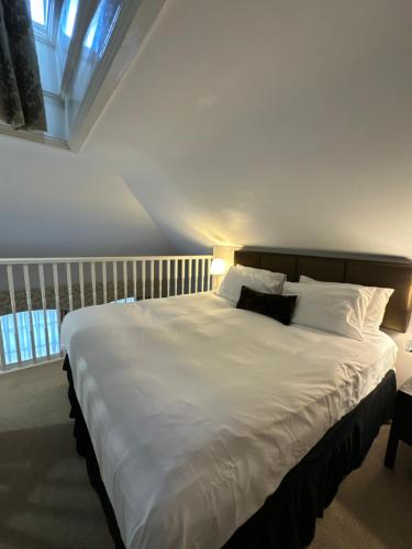 德比Cathedral Quarter Hotel - Derby的卧室配有一张带白色床单和枕头的大床。