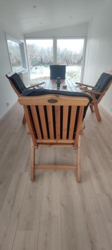 英斯约Semesterhus i Yngsjö的一张木桌,房间周围摆放着椅子