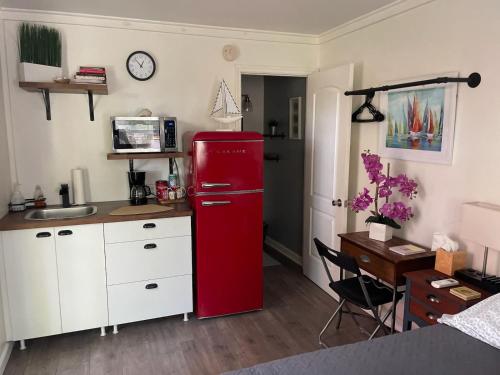 坦帕Lovely Studio Apartment with Kitchenette.的带书桌的厨房内的红色冰箱