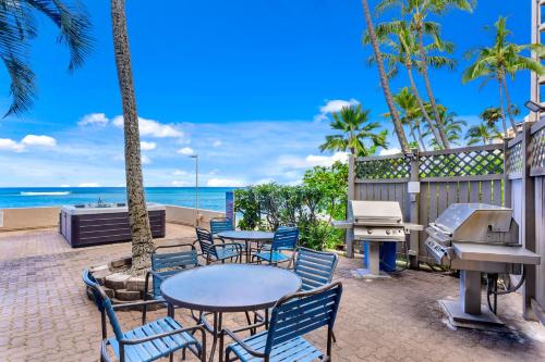 拉海纳卡哈纳海滩度假俱乐部酒店的一个带桌椅的庭院和海滩