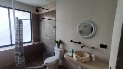 梅里达Casa Kuxul的一间带卫生间、淋浴和镜子的浴室