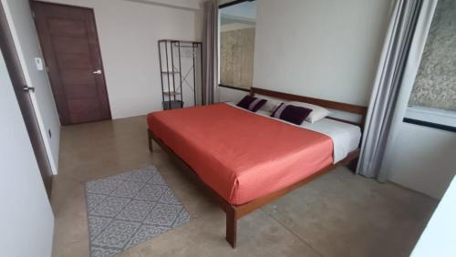 梅里达Casa Kuxul的一间卧室配有一张红色座椅的床