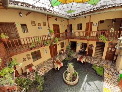 卡哈马卡Casa Bonita Colonial的建筑中带椅子和盆栽的室内庭院