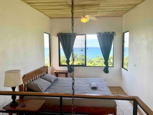 San PedrilloCotinga Nest - King Bed, Ocean View的卧室设有秋千床,享有海景