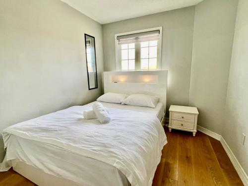 多伦多House In Scarborough 20 Minutes to Downtown的卧室设有一张白色大床和一扇窗户。