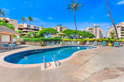 拉海纳卡哈纳别墅酒店的一座带椅子和棕榈树的度假村游泳池
