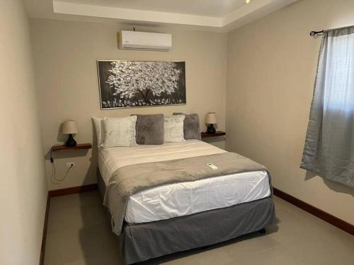 南圣胡安Chabayali House的卧室配有一张床,墙上挂有绘画作品