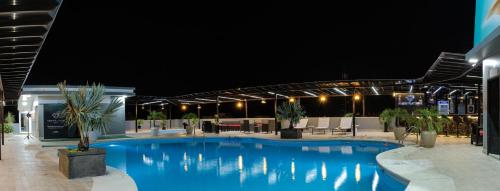 通苏帕Green Platinum Hotel的夜间大型蓝色游泳池