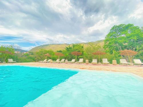 圣希尔Trip Monkey del Río的度假村的游泳池,配有椅子和遮阳伞