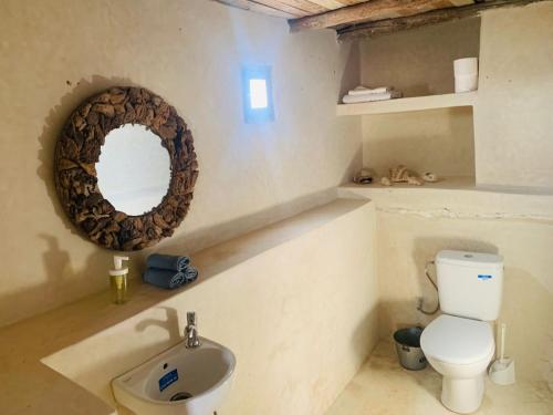 AghnajaneMomo's beach house的浴室设有卫生间和墙上的镜子。