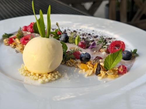 OckfenWeinhotel Restaurant Klostermühle的白盘上的甜点,包括浆果和冰淇淋
