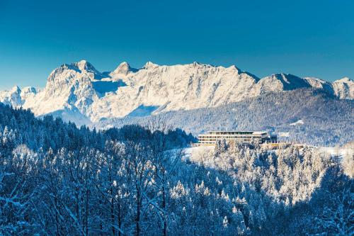贝希特斯加登贝希特斯加登凯宾斯基酒店的一片雪覆盖的山脉,前方有一座建筑