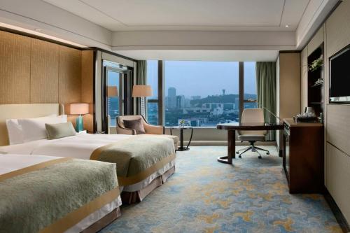 厦门厦门源昌凯宾斯基大酒店的酒店客房配有两张床和一张书桌