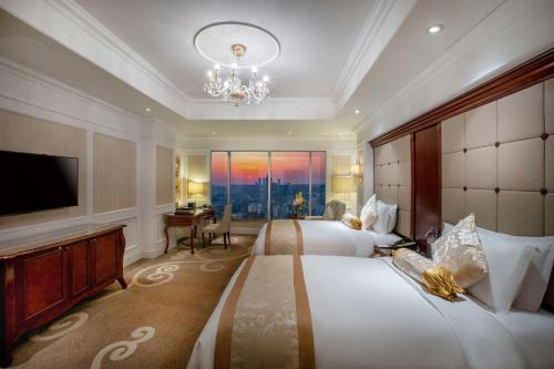 贵阳贵阳凯宾斯基大酒店的大型酒店客房设有两张床和电视。