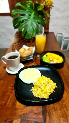 Majestic Coffee Hotel and Restaurant Tierradentro的一张桌子,上面放着一盘炒鸡蛋和水果