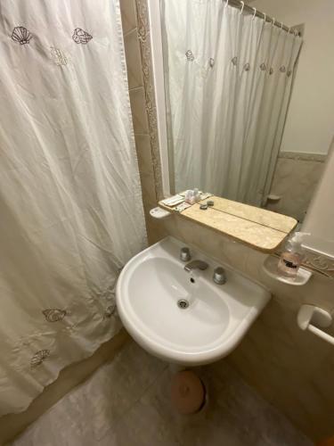 内乌肯Cerquita de Shopping: depto amoblado urbano的浴室配有白色水槽和淋浴。
