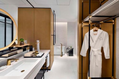 杭州杭州远洋凯宾斯基酒店的浴室设有挂在架子上的白色长袍
