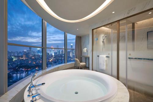 南京南京凯宾斯基酒店的一间带大浴缸和大窗户的浴室
