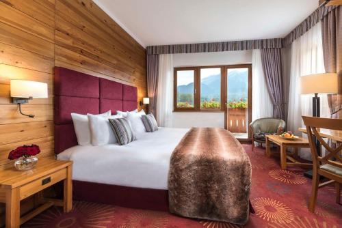班斯科Kempinski Hotel Grand Arena Bansko的一间设有大床和窗户的酒店客房
