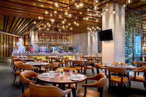 长沙长沙凯宾斯基酒店 的一间带桌椅的餐厅和一间酒吧