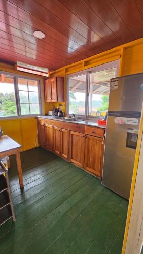 博卡斯德尔托罗Bastimentos Hill Guest House的厨房配有木制橱柜和不锈钢冰箱。