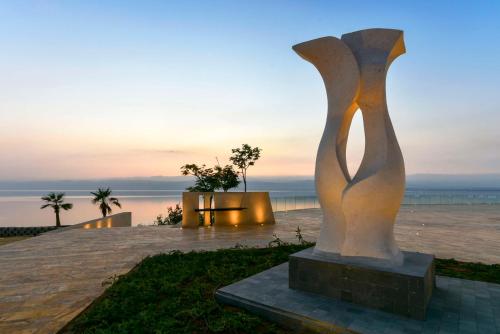 索瓦马伊什塔尔死海凯宾斯基酒店的日落时在海洋前的雕像