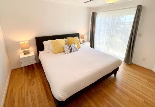 圣地亚哥Hidden Gem with Hot Tub and Parking - 4 Guests的一间卧室配有带白色床单和黄色枕头的床。