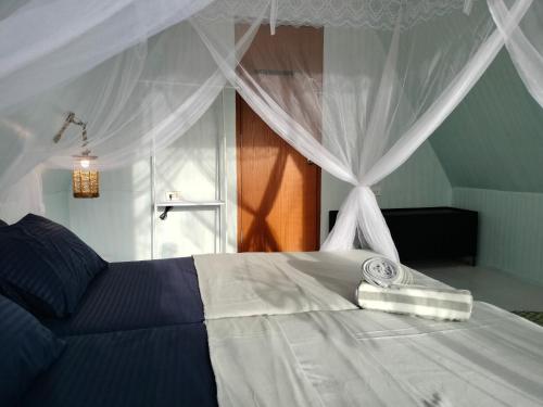 道伊斯Riu del Mar Hostel的一间卧室配有一张带天蓬的白色床
