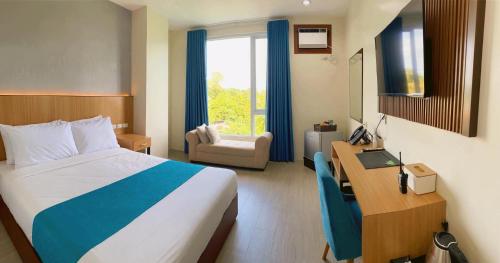 卡利博JRP Vanyard Resort Hotel的酒店客房 - 带一张床、一张桌子、一张床和椅子