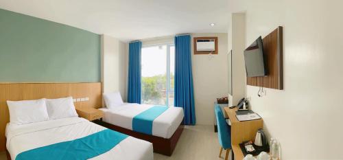 卡利博JRP Vanyard Resort Hotel的酒店客房设有两张床和电视。