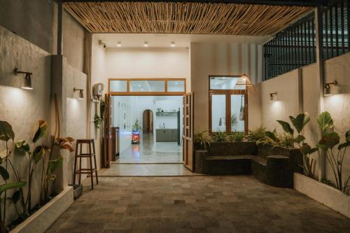 Kinh DinhNagi cottage的开放式走廊,种植了盆栽植物,设有门廊