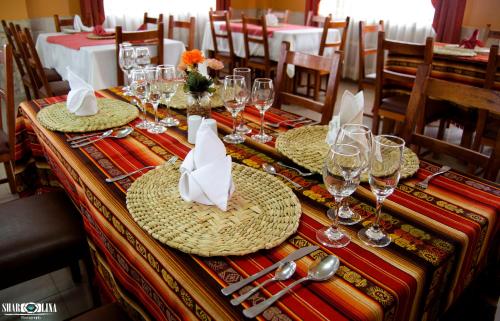 San AndrésHotel San Andrés的长桌,带盘子,玻璃杯和餐巾