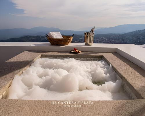 塔斯科·德·阿拉尔孔De Cantera Y Plata Hotel Boutique的一座建筑物顶部的浴缸里满是云