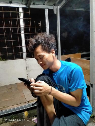 BulakIfrazim home peninggilan的一个年轻人正在看手机