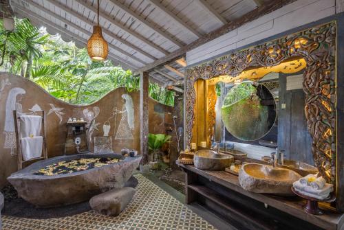 帕洋安Pramana Giri Kusuma的一间带大浴缸和大镜子的浴室