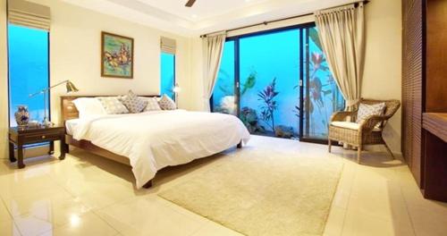 波普托villa lavanya的一间卧室设有一张大床和一个大窗户