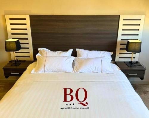 布赖代البندقية للأجنحة الفندقية بريدة BQ hotel suites的一间卧室,床上有标牌