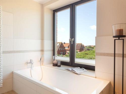 于斯德Reethuus Süd Modern retreat的带浴缸的浴室和窗户。